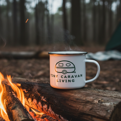 Green Tiny Caravan Living caravan logo on an enamel mug around a campfire setting