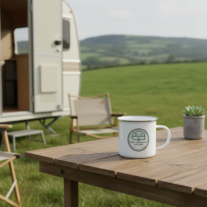 Tiny Caravan Living Signature Badge enamel mug on a table beside a caravan